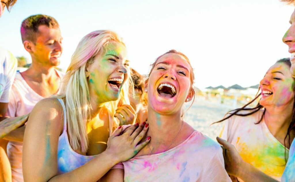 happy-friends-group-having-fun-at-beach-party-on-holi-festival-summer-vacation.jpg