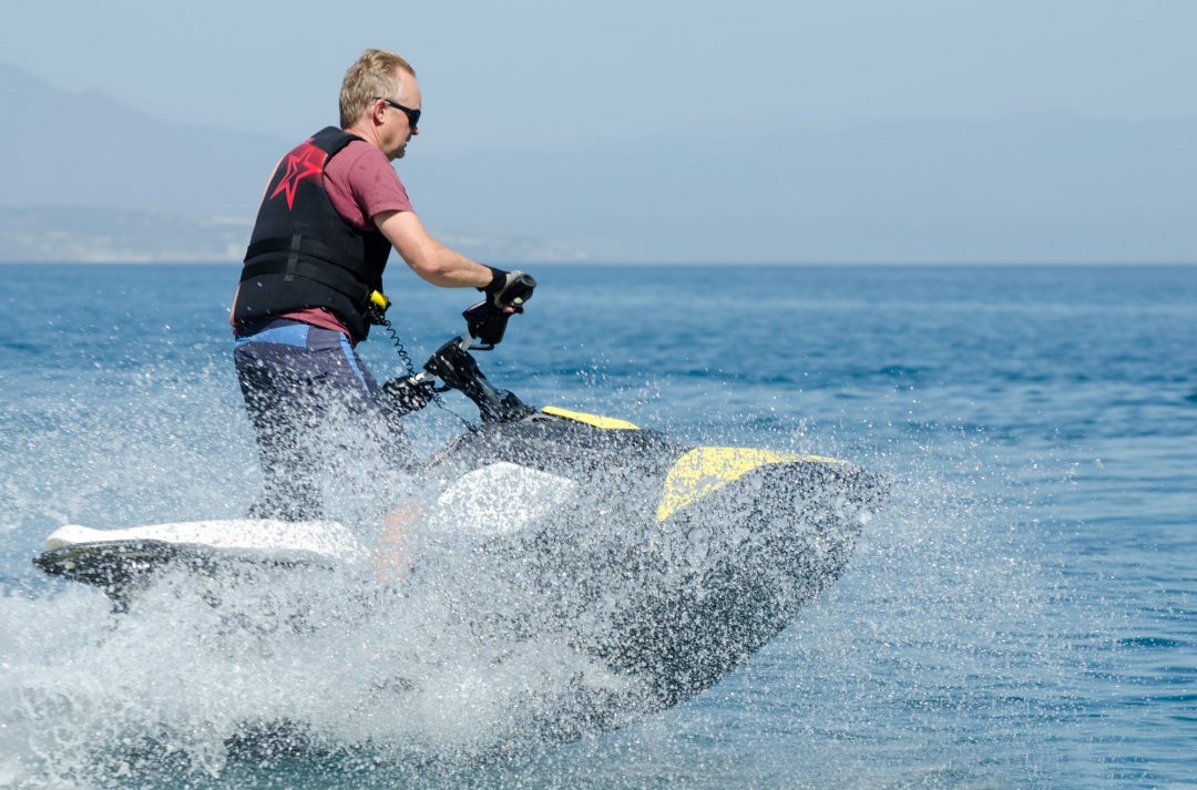 man-standing-up-while-driving-a-jet-ski-surrounded-by-sea-spray.jpg